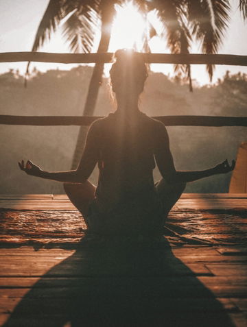 woman doing yoga meditation on brown parquet flooring